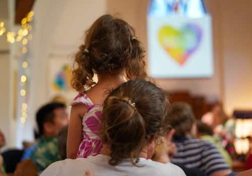 Mother child from behind watching carols church service Christmas